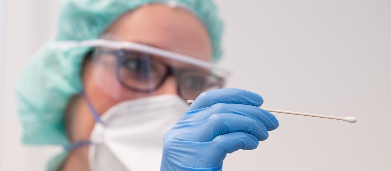 Eine Krankenschwester hält in einem Behandlungszimmer der Corona-Ambulanz in der Paracelsus-Klinik Zwickau ein Abstrichstäbchen.