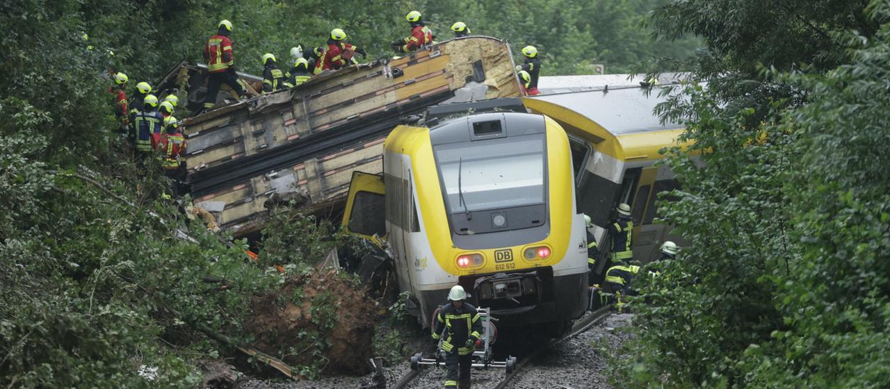 Rettungskräfte suchen in einem entgleisten im baden-württembergischen Kreis Biberach nach Fahrgästen.