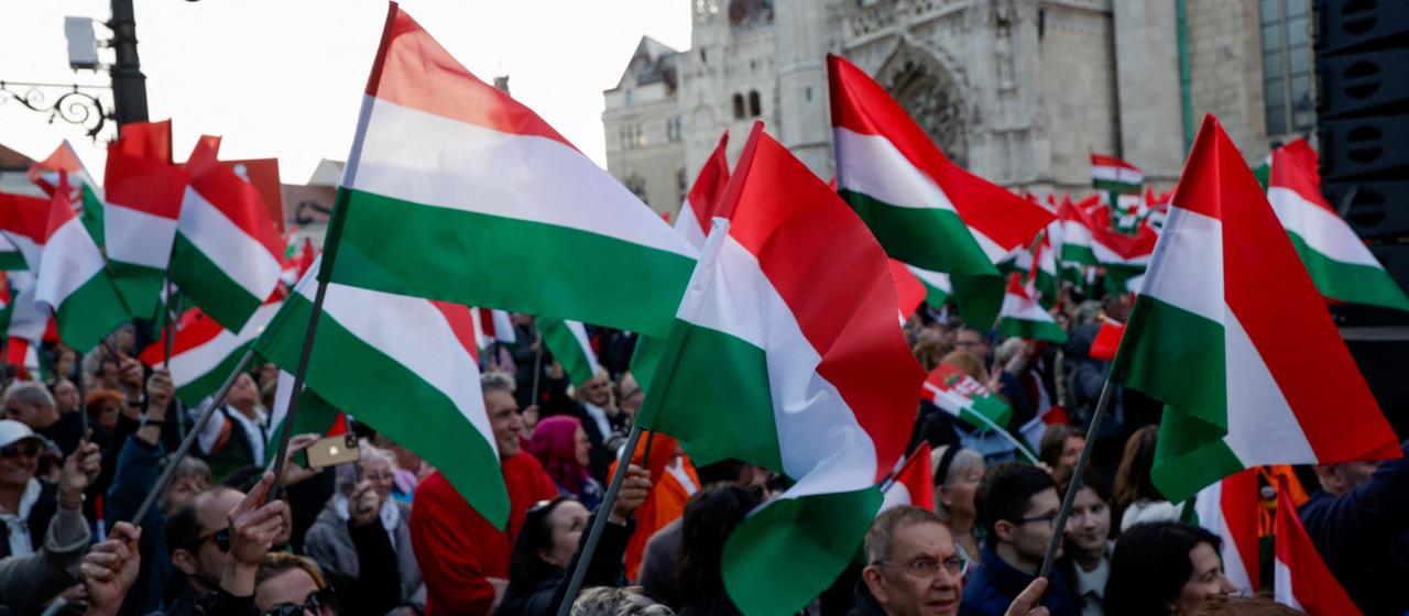 Demonstrierende in Budapest schwenken ungarische Flaggen.