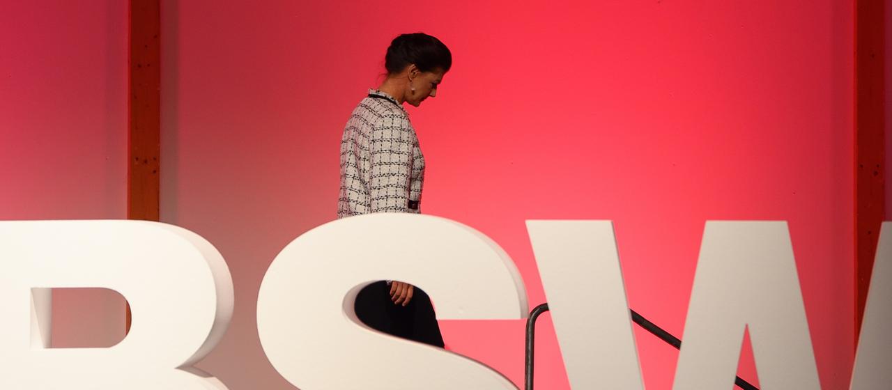 Sahra Wagenknecht hinter einem BSW-Schriftzug 