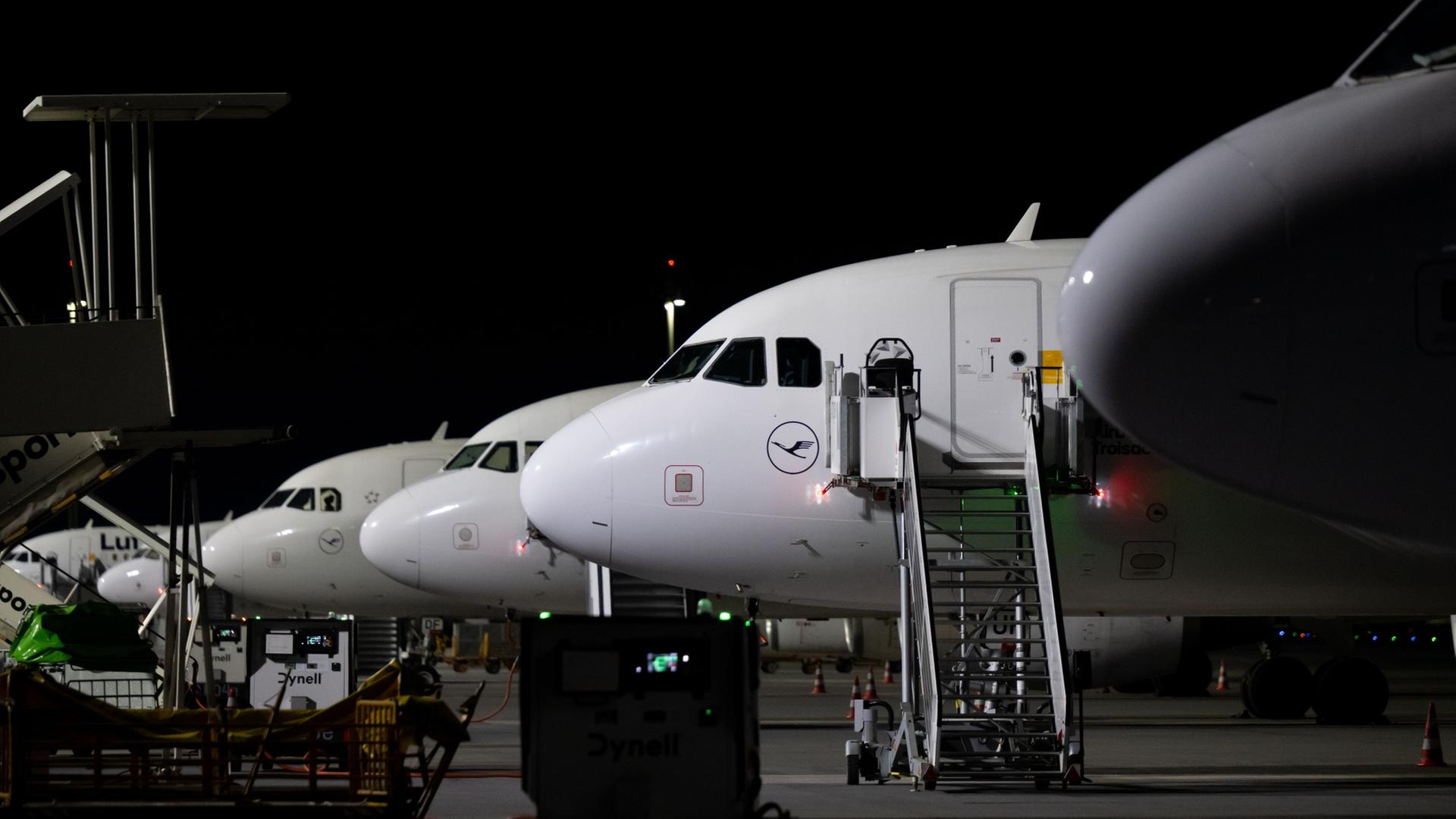 Flugzeuge der Lufthansa stehen bei Nacht auf einem Parkplatz | Sven Hoppe/dpa