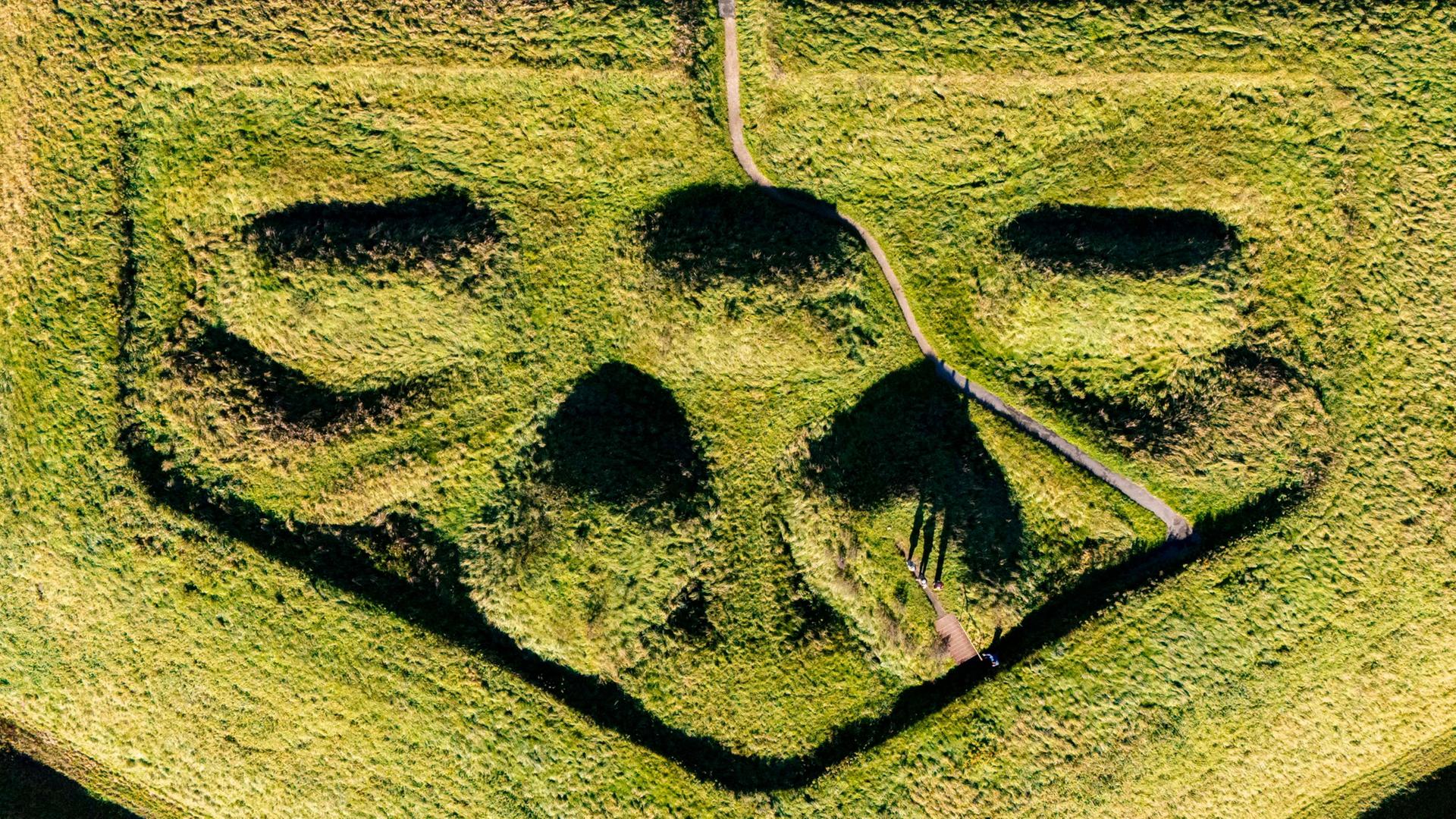 Besucher stehen bei Sonnenschein auf der Schanze 14 im neugestalteten ArchÃ¤ologischen Park am UNESCO-Welterbe Haithabu-Dannewerk. | Frank Molter/dpa