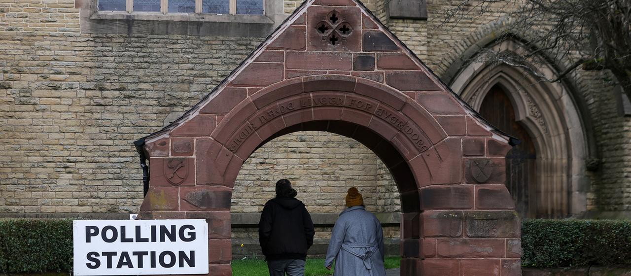 People arrive at a polling station at St Peter's Church in Manchester.