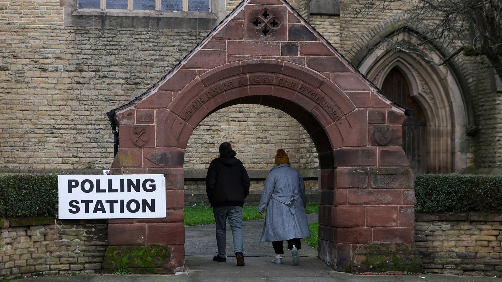 Menschen kommen zu einem Wahllokal in der St. Peter's Church in Manchester. | REUTERS
