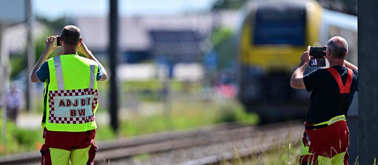 Rettungskräfte machen am Bahnübergang Vierhuizen in Buggenhout mit ihren Smartphones Aufnahmen.