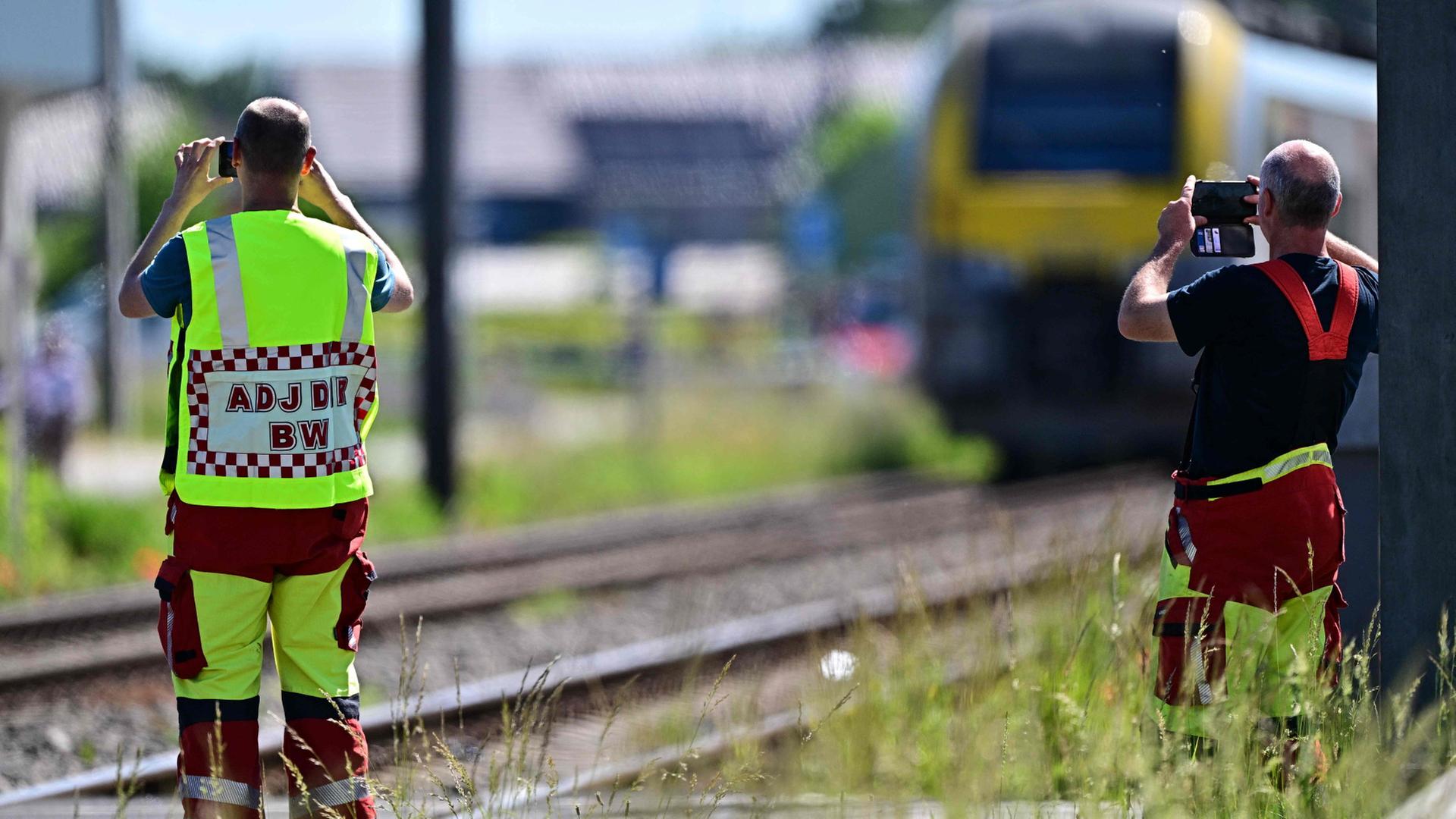 Rettungskräfte machen am Bahnübergang Vierhuizen in Buggenhout mit ihren Smartphones Aufnahmen. | AFP