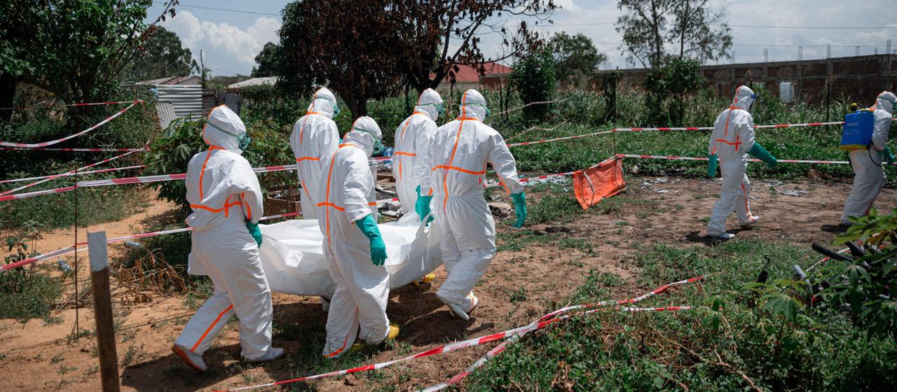 Freiwillige des Roten Kreuzes der Demokratischen Republik Kongo tragen in Schutzausrüstung die Leiche eines Ebola-Opfers aus der Leichenhalle des Gesundheitszentrums Rwampara in der Provinz Ituri.