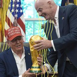 Gianni Infantino reicht Donald Trump den WM Pokal im weißen Haus.