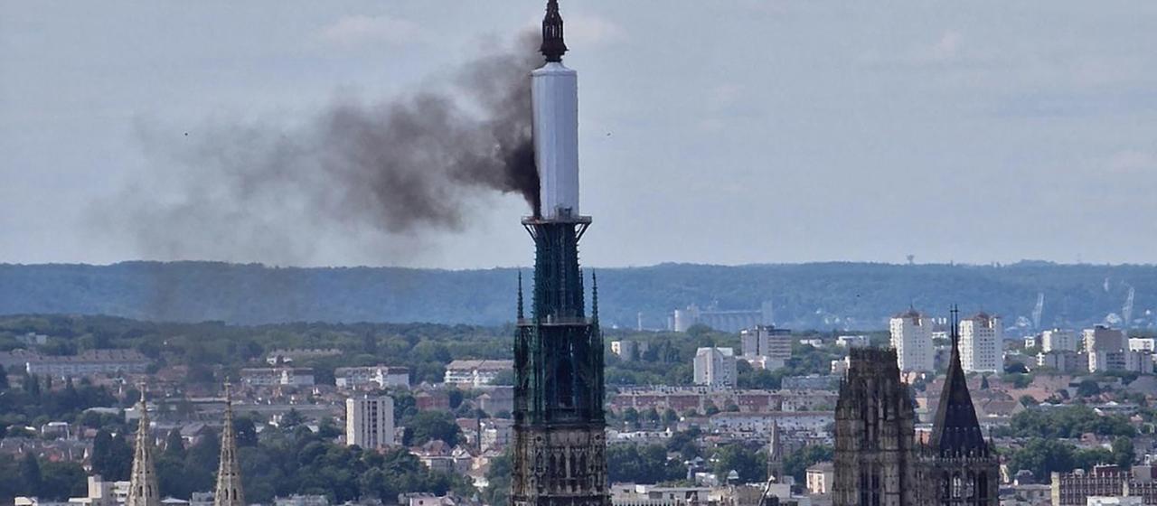 Vom Turm der Kathedrale von Rouen steigt eine Rauchwolke auf.