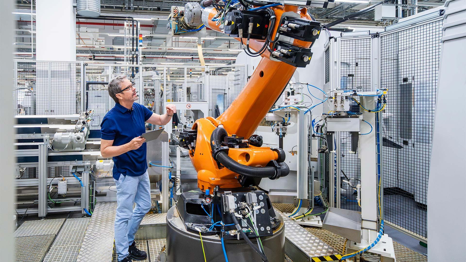 Mitarbeiter wartet einen Roboterarm. | picture alliance / Westend61