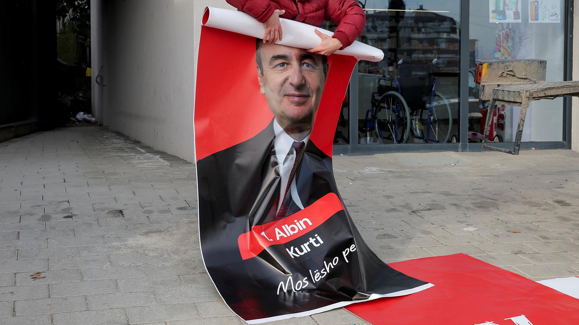 Ein Poster mit dem Bild von Albin Kurti wird eingerollt. | REUTERS