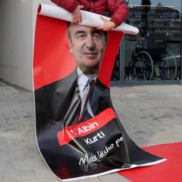 Ein Poster mit dem Bild von Albin Kurti wird eingerollt.