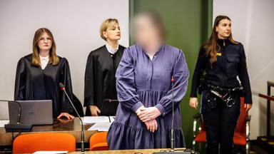 Die Angeklagte Andrea Tandler steht zu Prozessbeginn an ihrem Platz im Gerichtssaal vor ihren Rechtsanwältinnen.