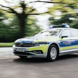 Ein Polizeiauto in Unschärfe fährt mit Blaulicht eine Straße in Hannover entlang.