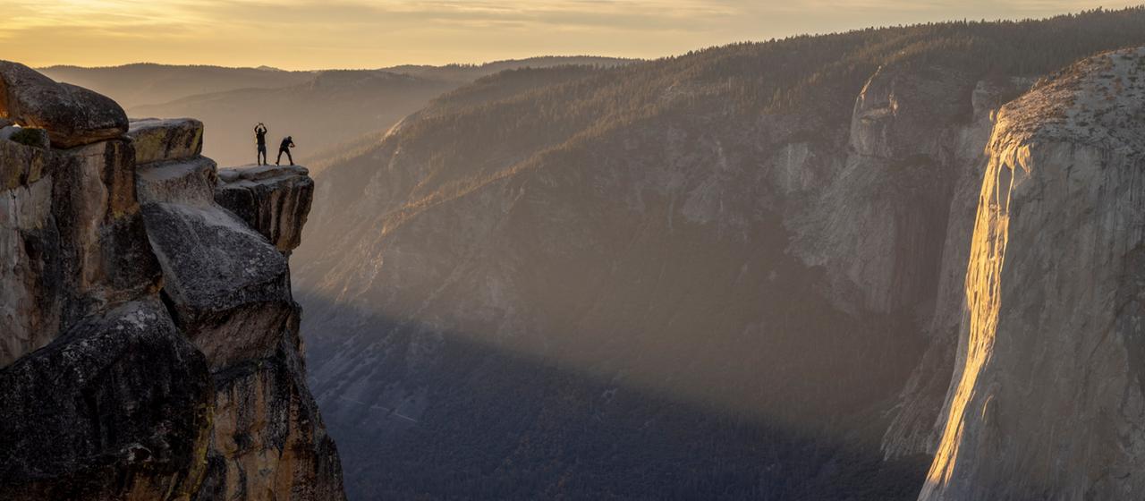 Besucher posieren auf einem Felsvorsprung im Yosemite Nationalpark für ein Foto