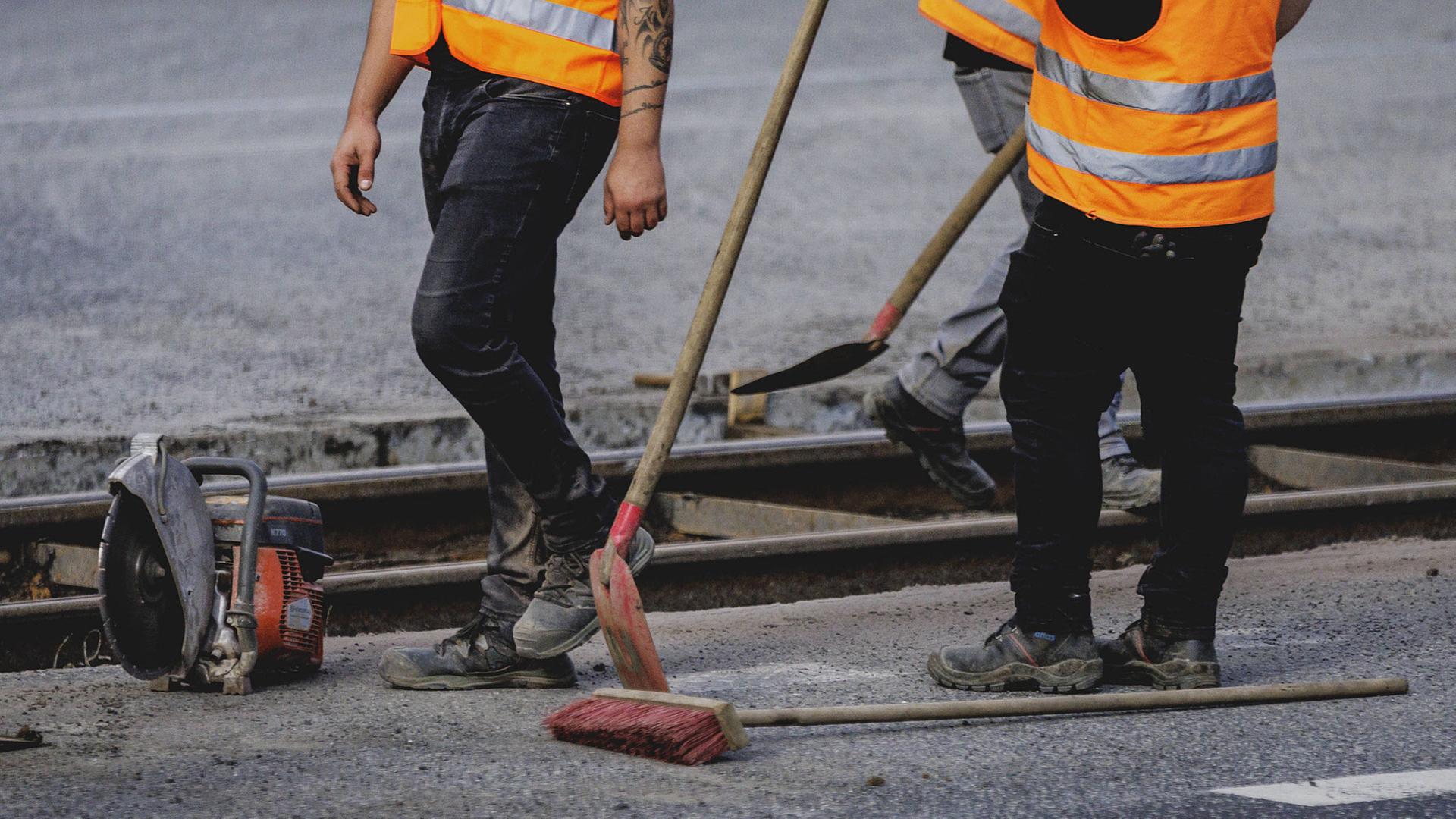 Bauarbeiter, die an einer Asphaltstraße arbeiten | IMAGO / photothek
