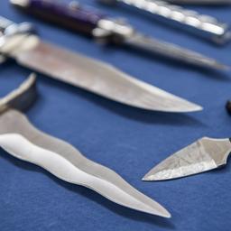  Messer mit einer Klingenlänge über sechs Zentimeter, ein beidseitig geschliffenes Messer und ein Faustmesser liegen bei einem Pressetermin der Bundespolizei auf einem Tisch. (Archivbild: 2018)