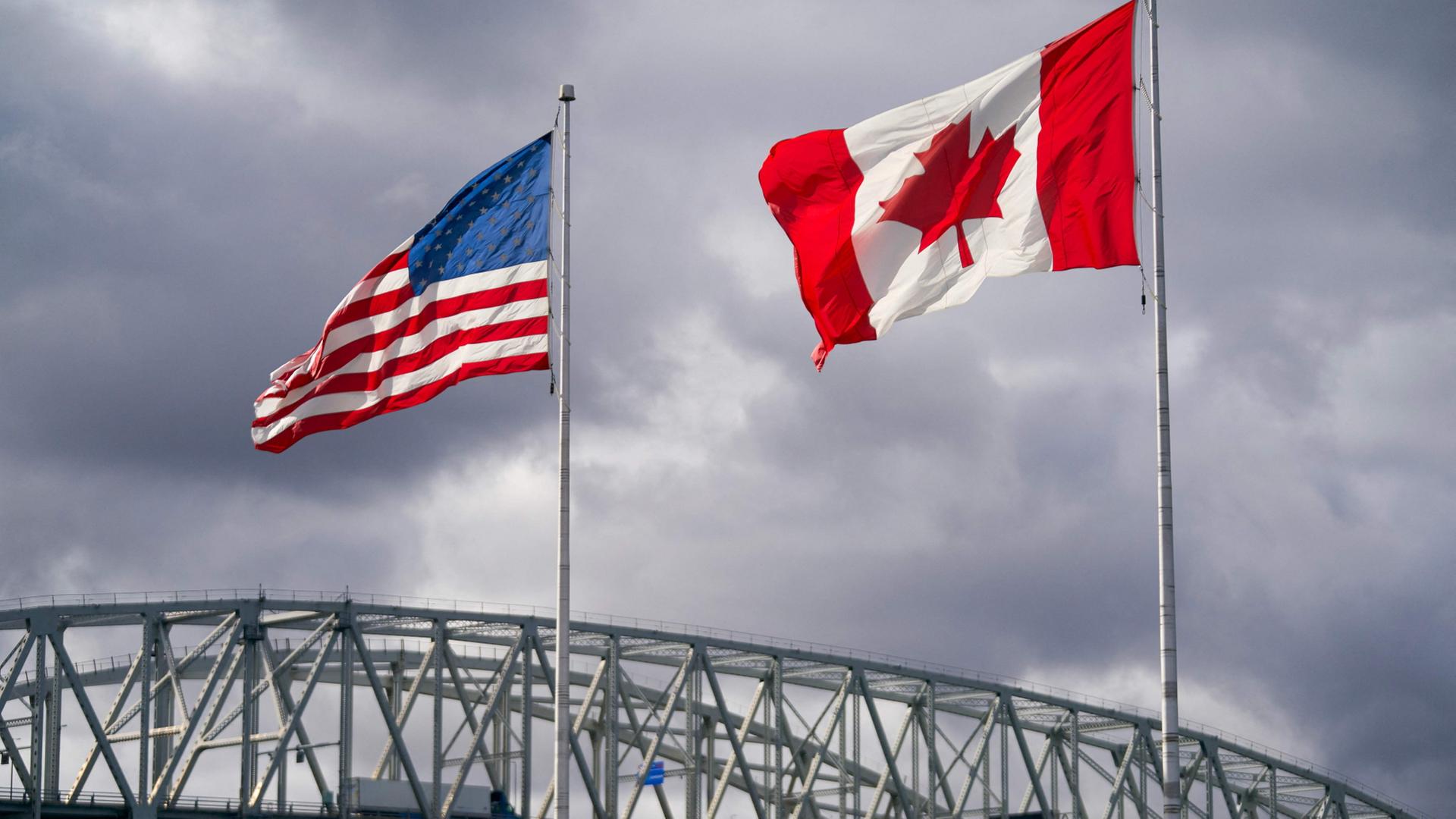 Die US- und kanadischen Flaggen wehen neben dem Grenzübergang Blue Water Bridge in Point Edward, Ontario, am 24. Oktober 2025. | AFP