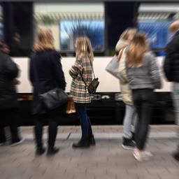 Bahnreisende stehen auf dem Bahnsteig. Das Bild zeigt Bewegungsunschärfen.