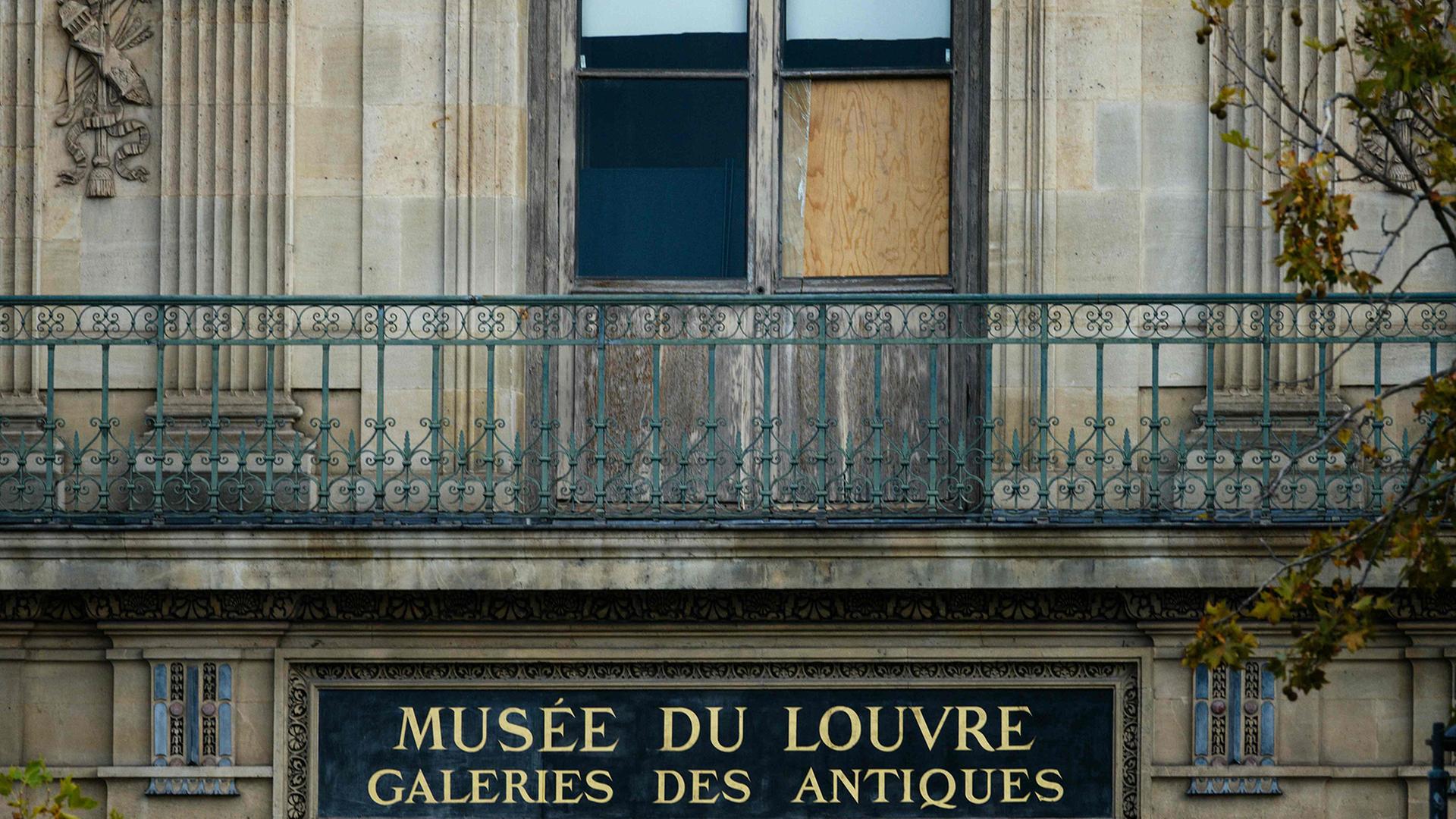 Ein kaputtes Fenster des Louvre-Museums ist mit einer Holzplatte abgedeckt. | AFP