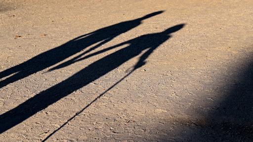 Lang gezogene Schatten zweiter Menschen mit Gehstock