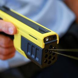 Ein Polizist hält eine Taser-Pistole.