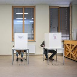 Wähler sitzen im Wahllokal im Gymnasium Rutheneum in Gera hinter Wahlkabinen. 