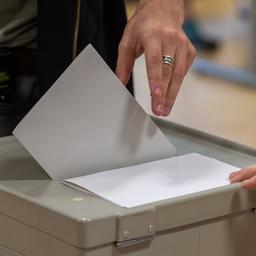 Ein Wähler wirft den Wahlzettel in einem Wahllokal in eine Wahlurne.