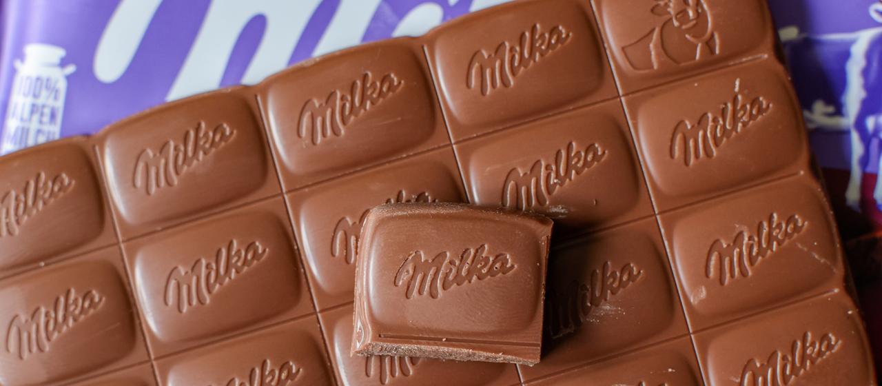 Eine Tafel Milka Alpenmilch Schokolade liegt auf einem Tisch.
