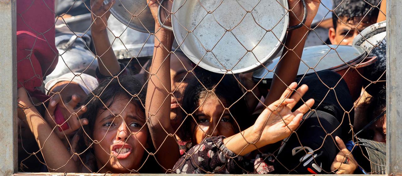 Palästinensische Kinder warten auf eine Mahlzeit in einer Wohltätigkeitsküche im Mawasi-Gebiet von Chan Junis im südlichen Gazastreifen. | AFP Palästinensische Kinder warten auf eine Mahlzeit in einer Wohltätigkeitsküche im Mawasi-Gebiet von Chan Junis im südlichen Gazastreifen.