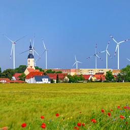 Windkraftanlagen hinter einem Dorf.