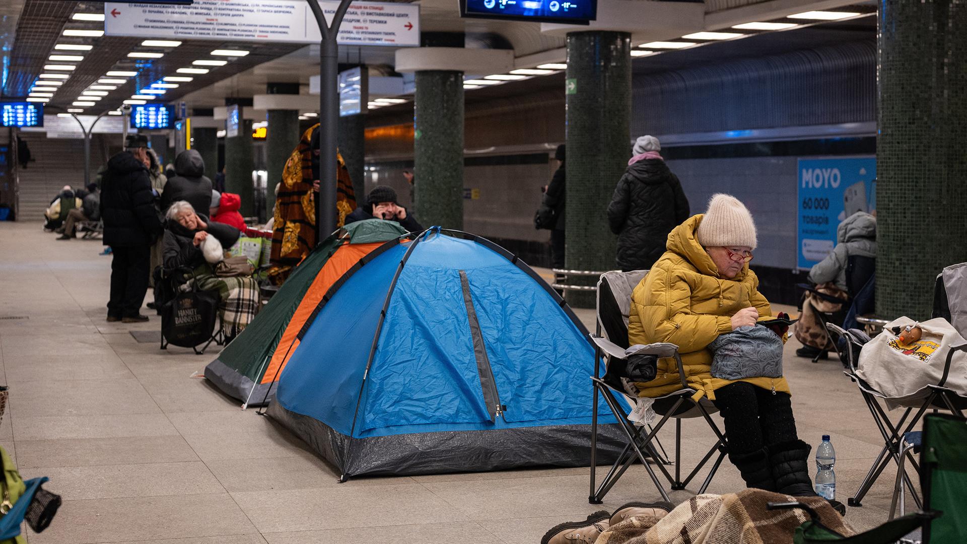 Menschen in dicker Winterkleidung haben in einer Metrostation Zelte und Campingstühle aufgeschlagen. | AP