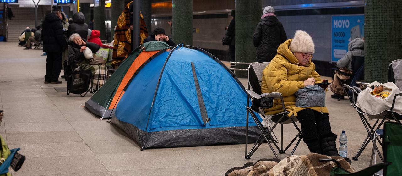 Menschen in dicker Winterkleidung haben in einer Metrostation Zelte und Campingstühle aufgeschlagen.
