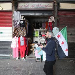 Ein syrischer Mann trägt die Flagge der Opposition auf dem al-Hamidiyeh-Markt in der Altstadt von Damaskus.