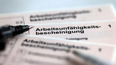 Stifte liegen auf den Arbeitsunfähigkeitsbescheinigungen für Arbeitnehmer im Falle einer Krankschreibung durch den Arzt.