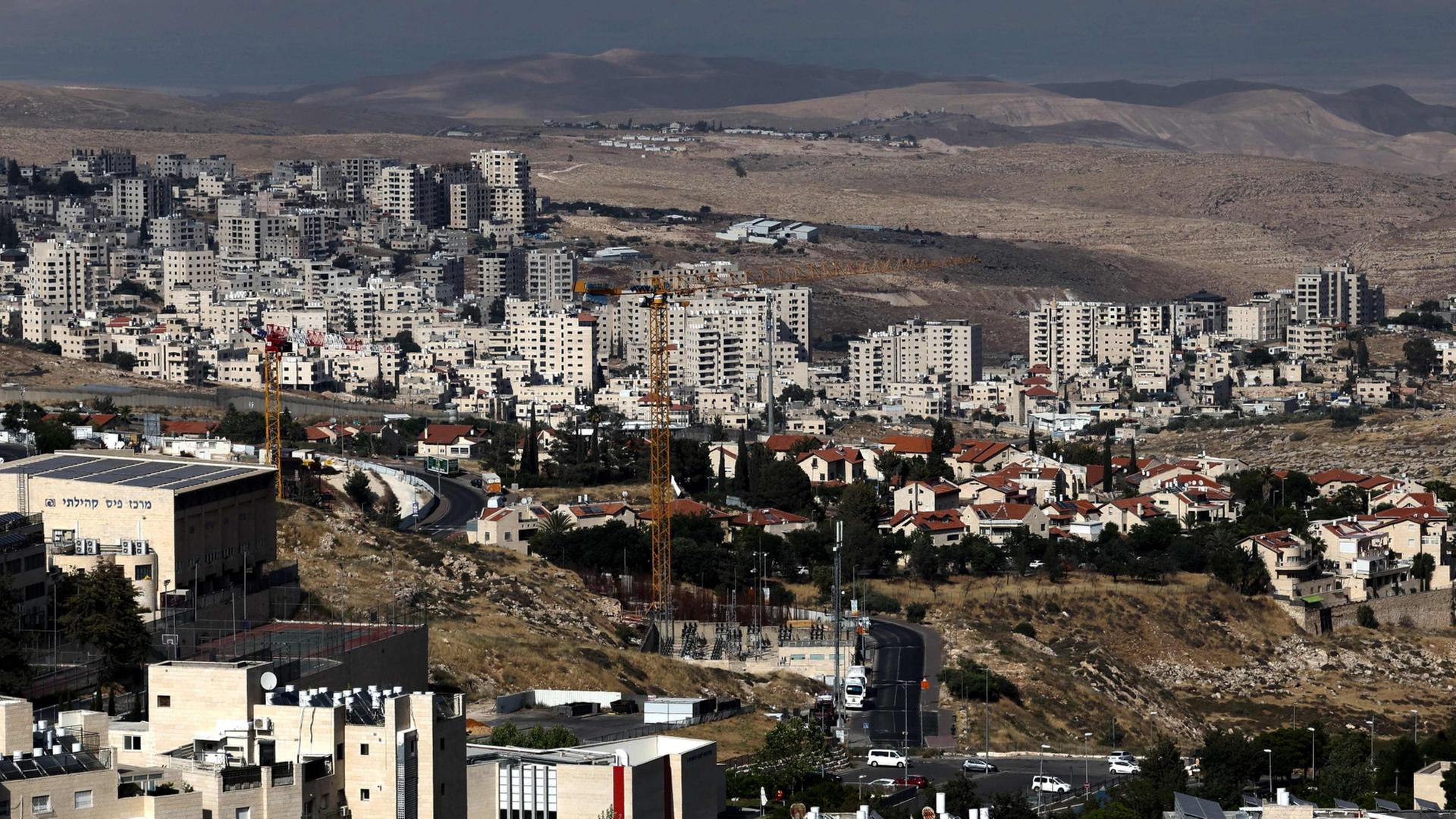 Die israelische Siedlung Pisgat Zeev im nördlichen Teil Ost-Jerusalems und die israelische Trennmauer, die die palästinensische Stadt Hzma (im Hintergrund) abtrennt, sind im besetzten Westjordanland zu sehen. | AFP
