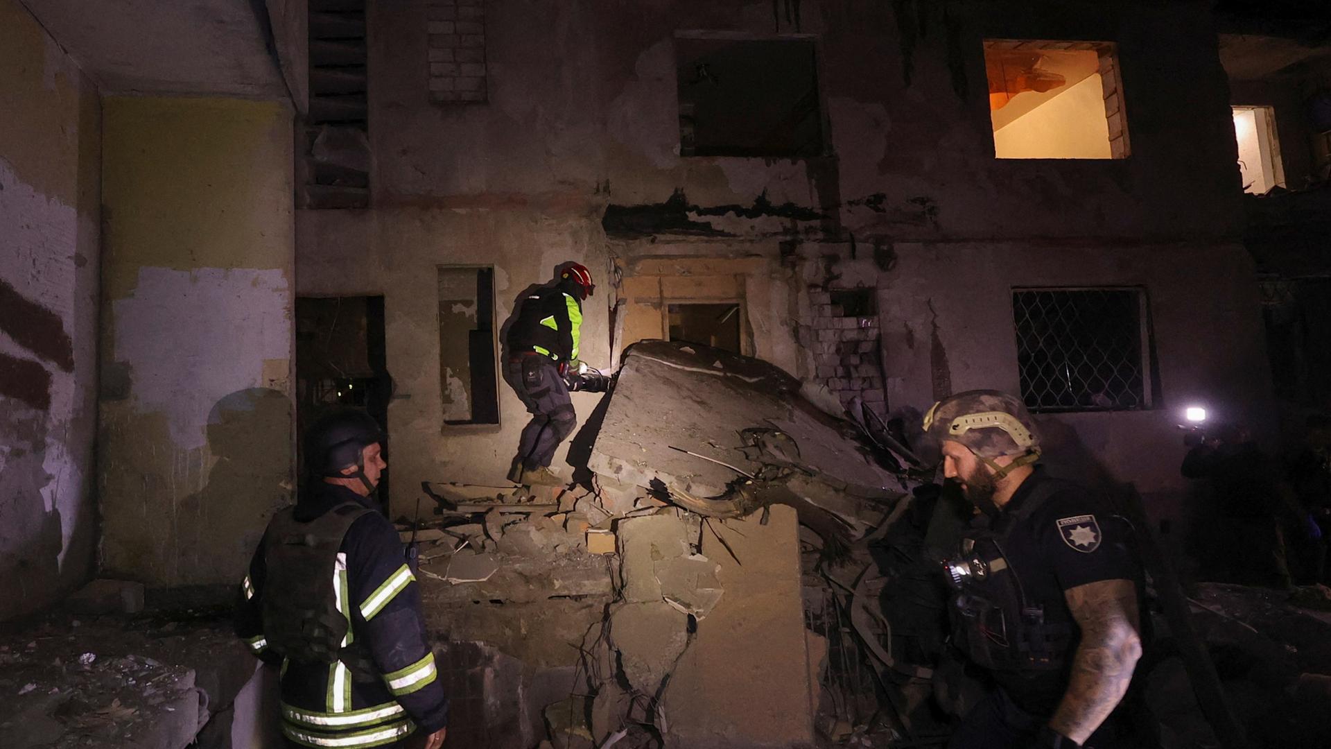 Rettungskräfte helfen bei einem Wohnhaus in Charkiw, das von einem russischen Luftangriff getroffen wurde.