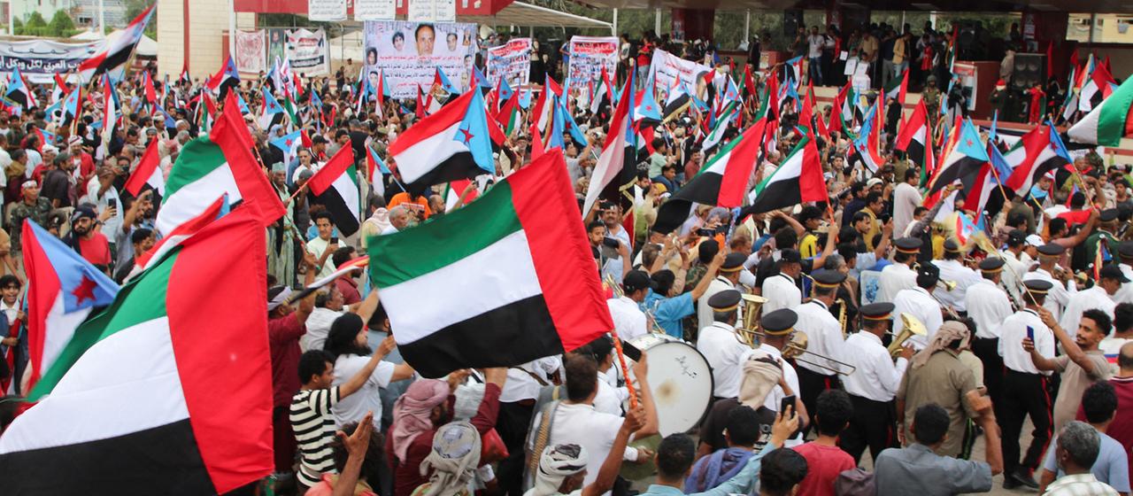 Menschen schwenken Flaggen der Vereinigten Arabischen Emirate und des STC während einer Kundgebung in Aden, Jemen.