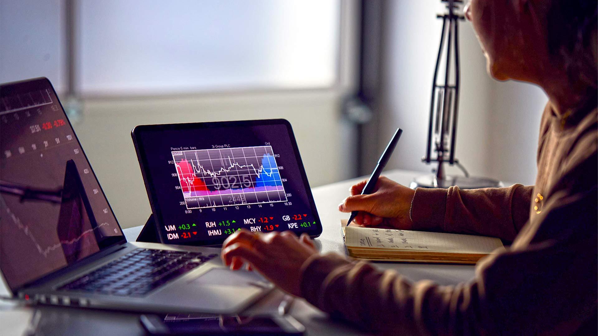 Eine Frau sitzt an einem Laptop und kontrolliert ihre Geldanlagen. | picture alliance / Shotshop