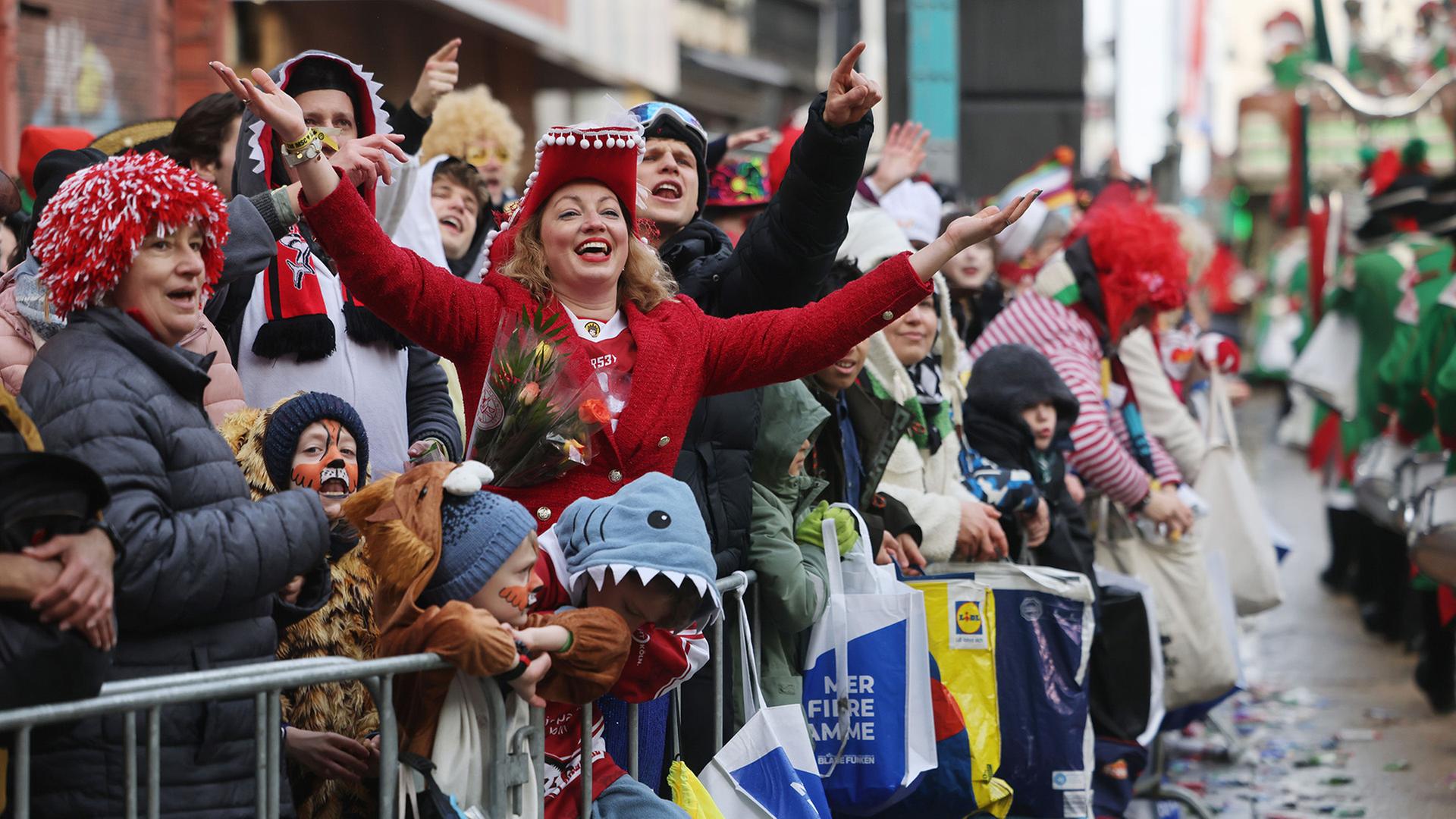 Karnevalisten feiern am StraÃenrand beim Rosenmontagszug in KÃ¶ln. | Oliver Berg/dpa