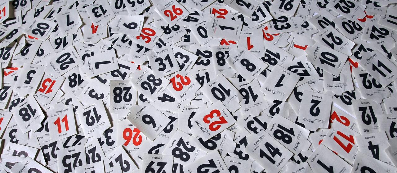 Blätter eines Abreißkalenders liegen verstreut aufeinander