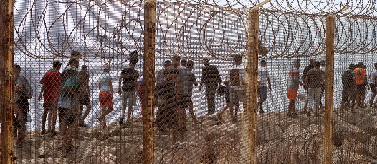 Migranten hinter dem Grenzzaun von Ceuta