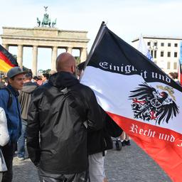 Berlin: Ein Teilnehmer hält vor einer Demonstration gegen die Corona-Maßnahmen eine Reichsflagge vor dem Brandenburger Tor
