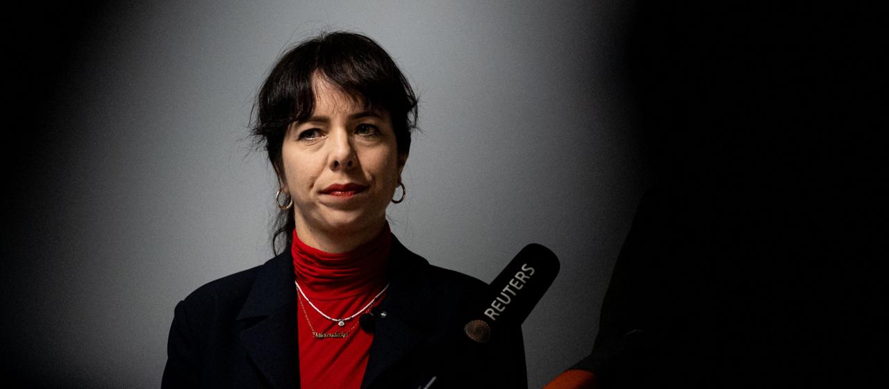 Elif Eralp steht vor einem Mikrofon.