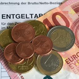Euro- und Centmünzen liegen auf einem 10-Euro-Schein und bilden den kommneden Mindestlohn von 13,90 Euro.