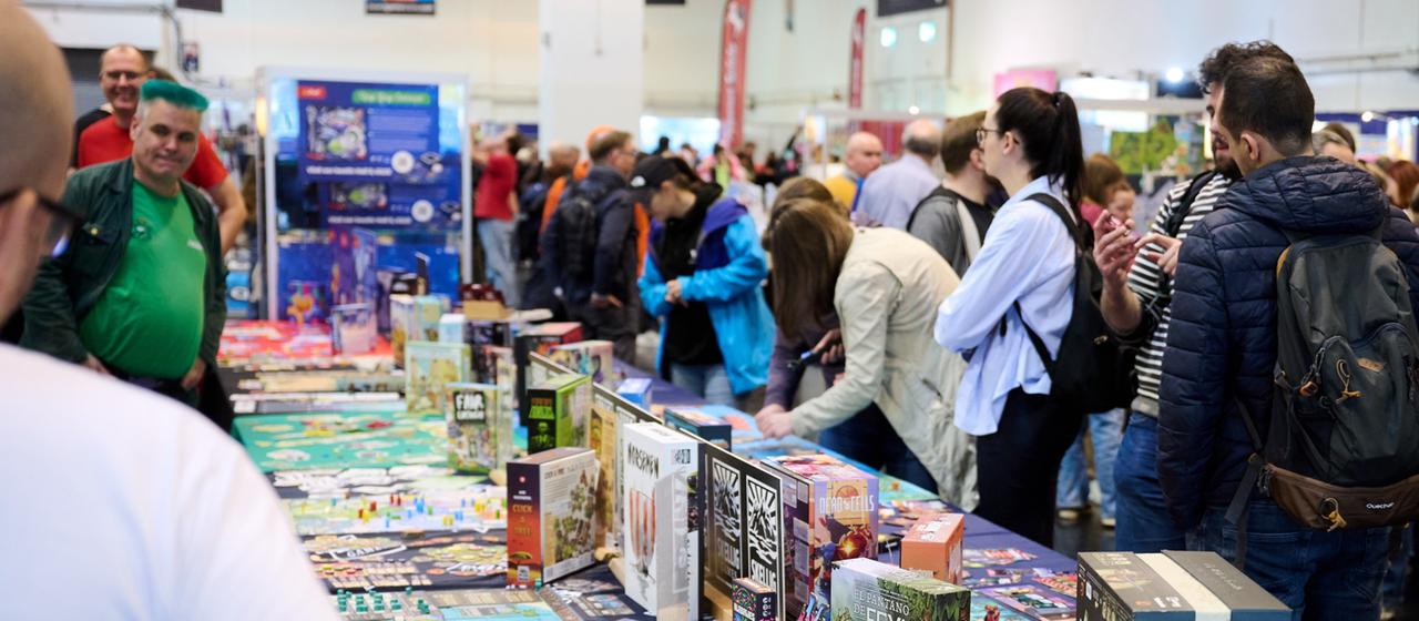 Besucher stehen beim Medien-Rundgang der internationalen Publikumsmesse "Spiel Essen 2025".
