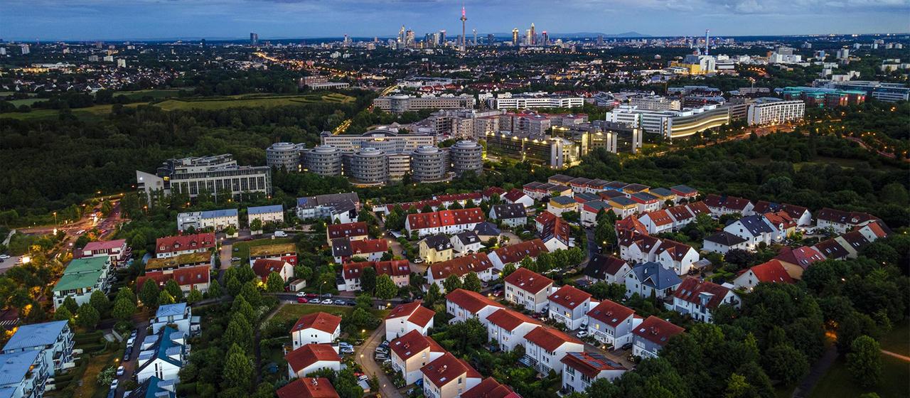 Wohnsiedlung im Frankfurter Speckgürtel und im Hintergrund die Skyline der Innenstadt.