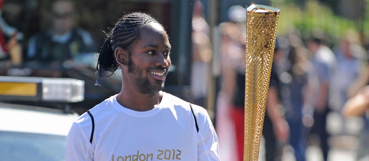Jason Arday, trägt im Jahr 2012 die olympische Fackel .