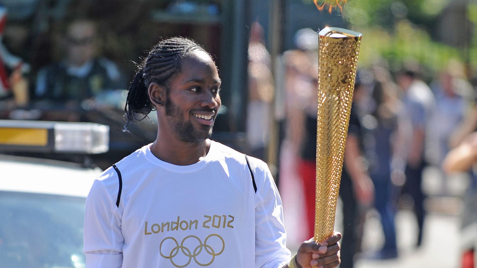 Jason Arday, trägt im Jahr 2012 die olympische Fackel .  | Joe Giddens/PA Wire/dpa