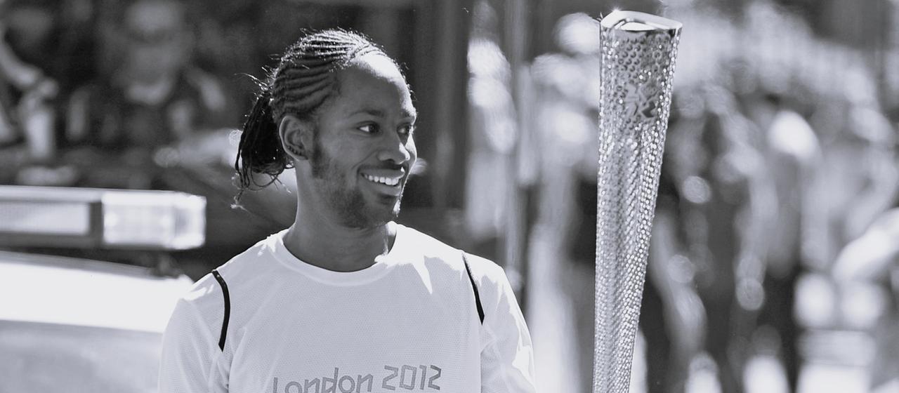 Jason Arday trägt im Jahr 2012 die olympische Fackel . 